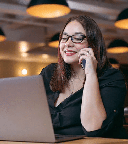 mulher trabalhando com notebook e atendendo o celular