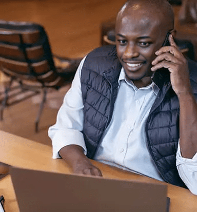 Homem negro trabalhando com celular e notebook